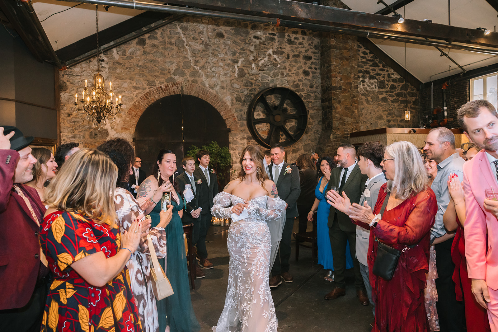 Bride walking back down the aisle smiling as guests applaud during Miners Foundry wedding in Nevada City, California.