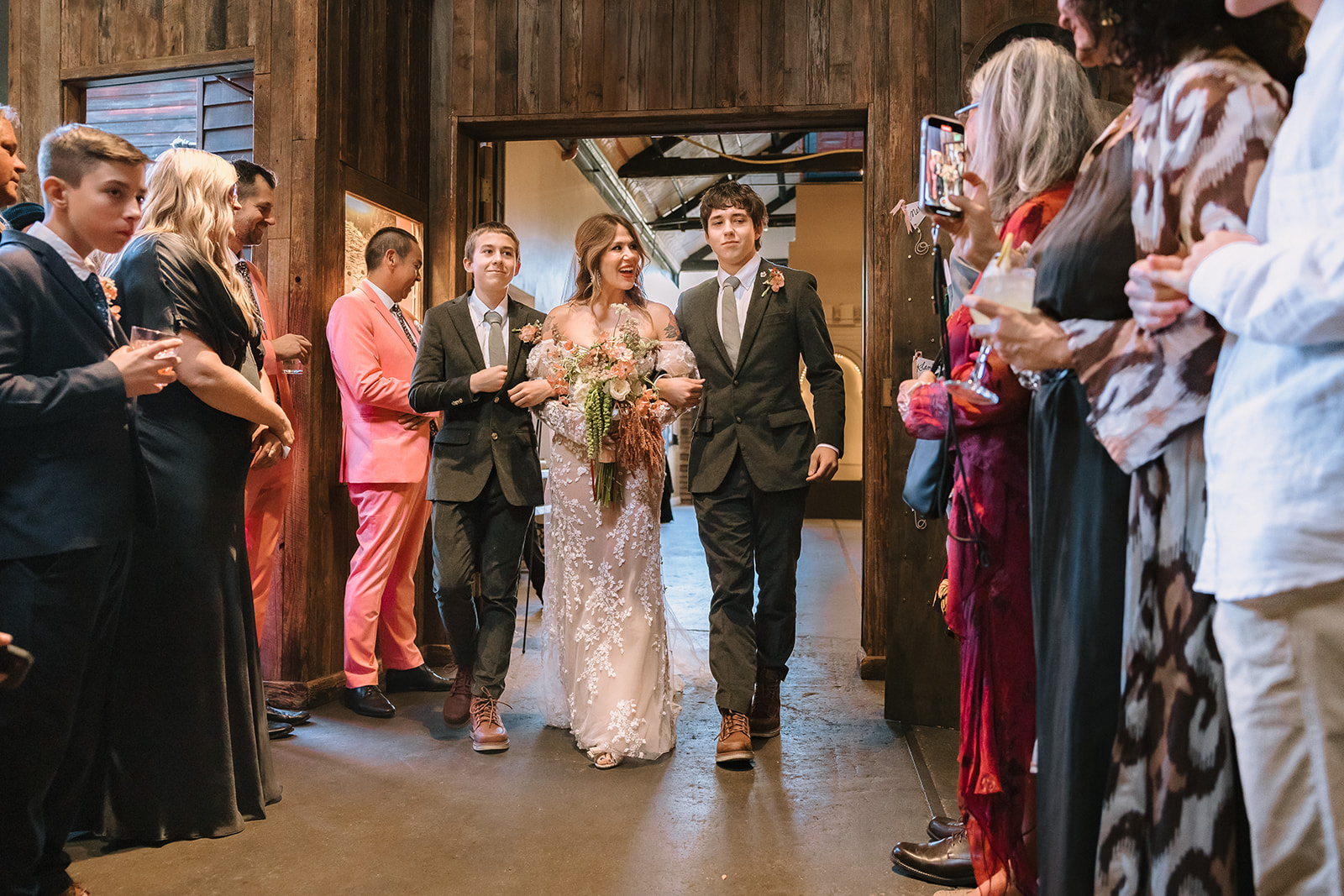 Bride walking down the aisle with her two sons during Miners Foundry wedding ceremony in Nevada City, California.