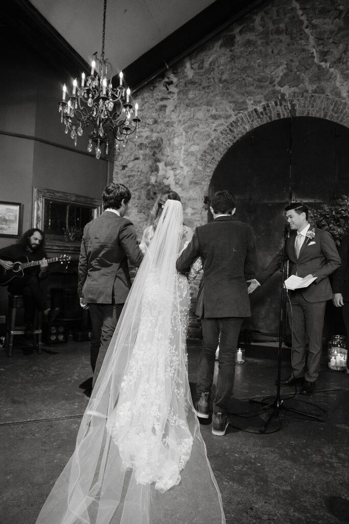 Bride walking to the altar with her sons at Miners Foundry wedding in Nevada City, California.