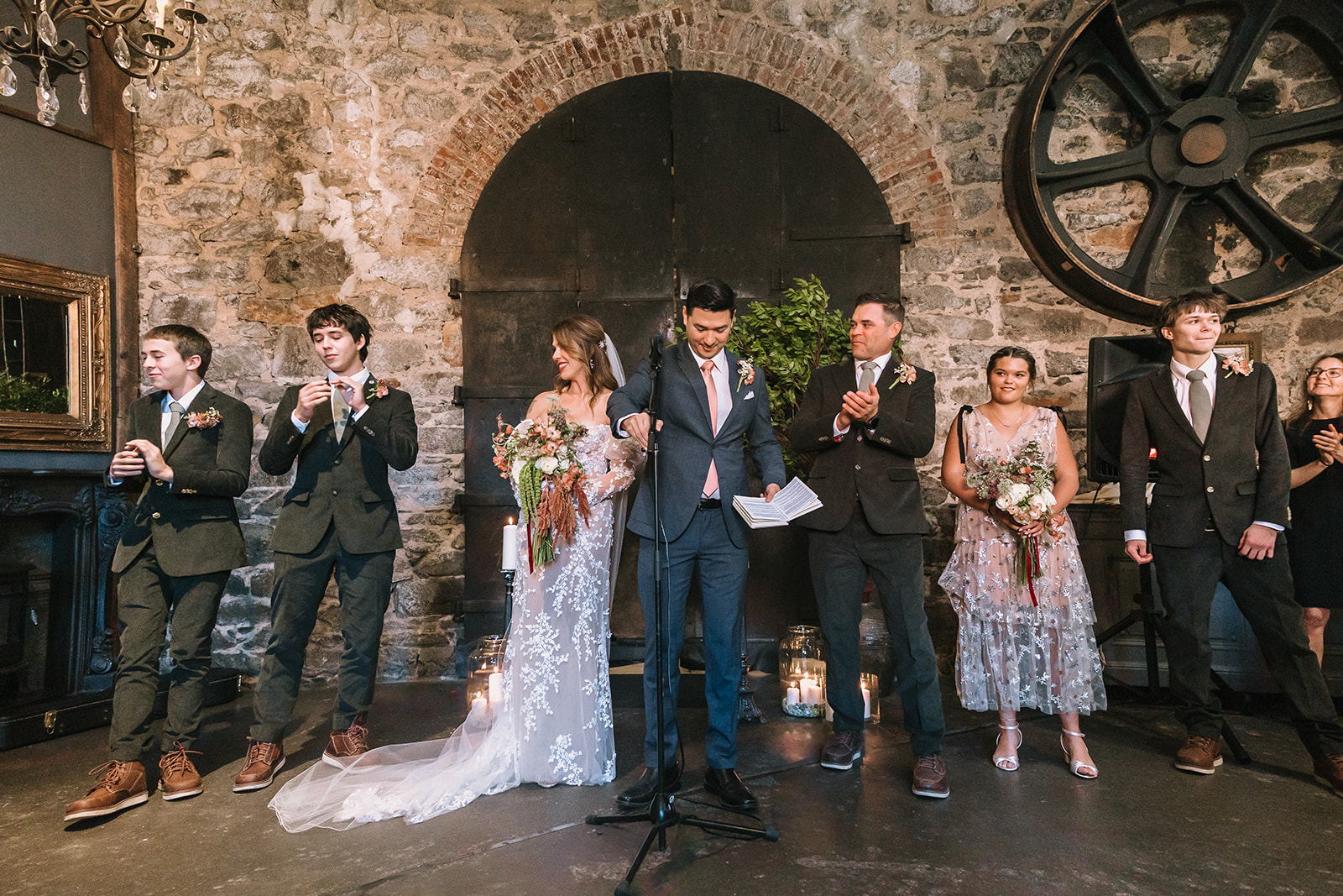 Wedding ceremony in the Upper Gallery with couple and family at the altar during Miners Foundry wedding in Nevada City, California.