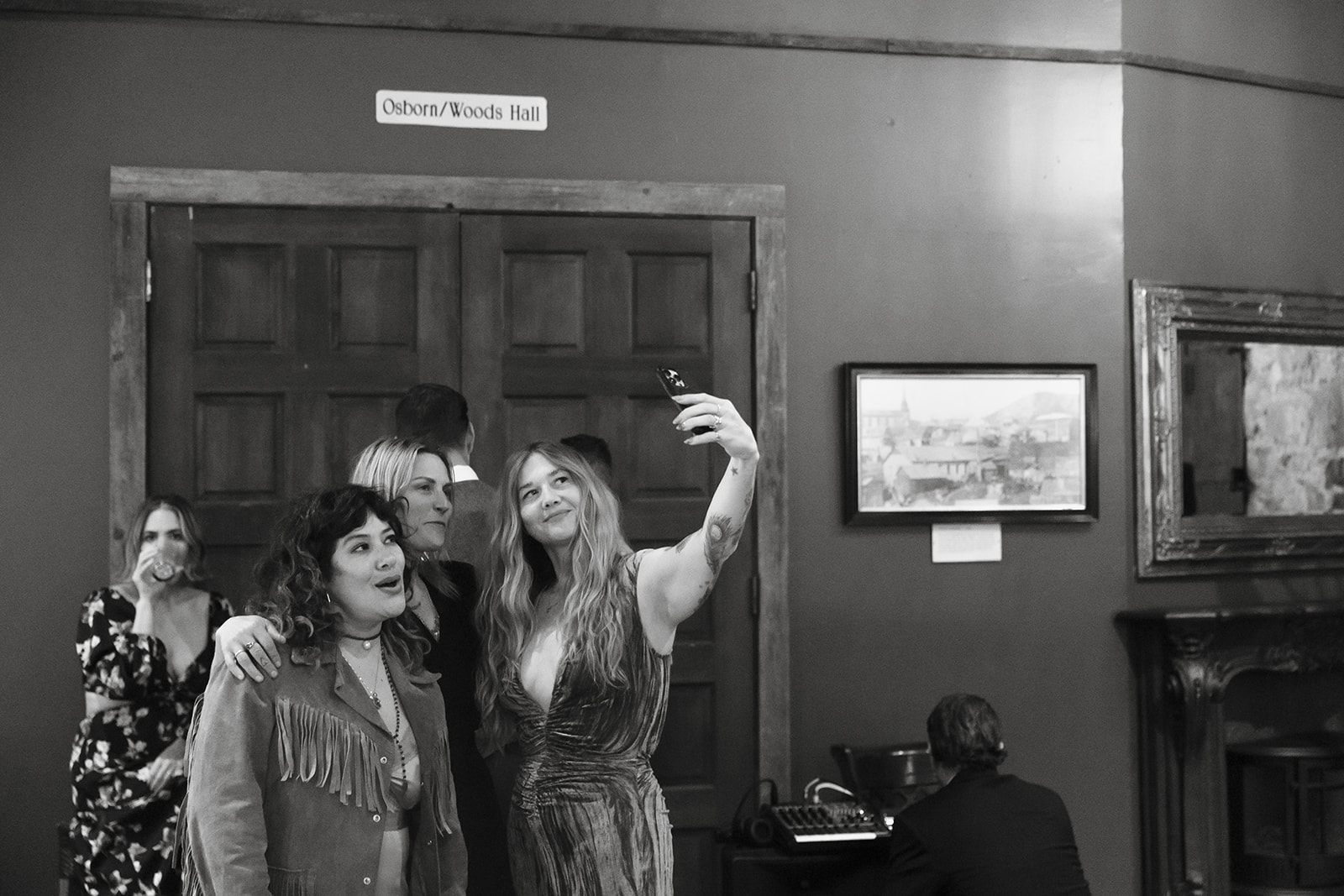 Guests taking a selfie during cocktail hour in the foyer at Miners Foundry wedding in Nevada City, California.