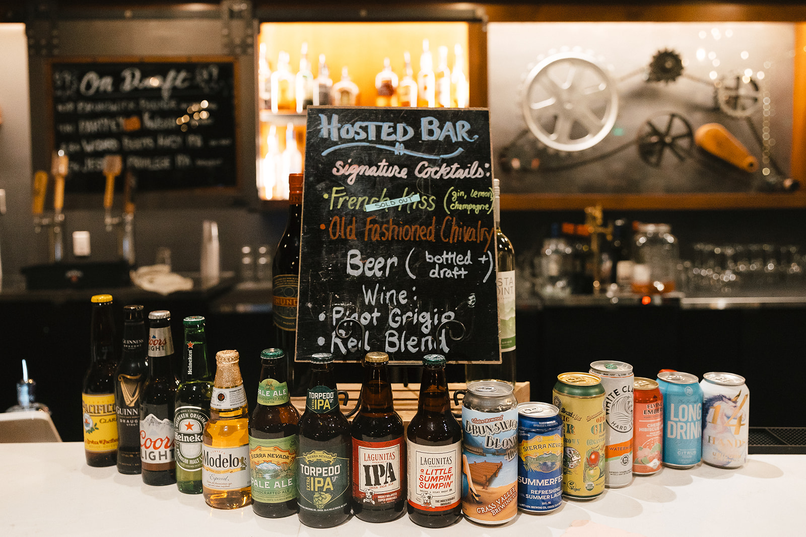 Bar setup with hosted bar menu and drinks displayed during reception at Miners Foundry wedding in Nevada City, California.