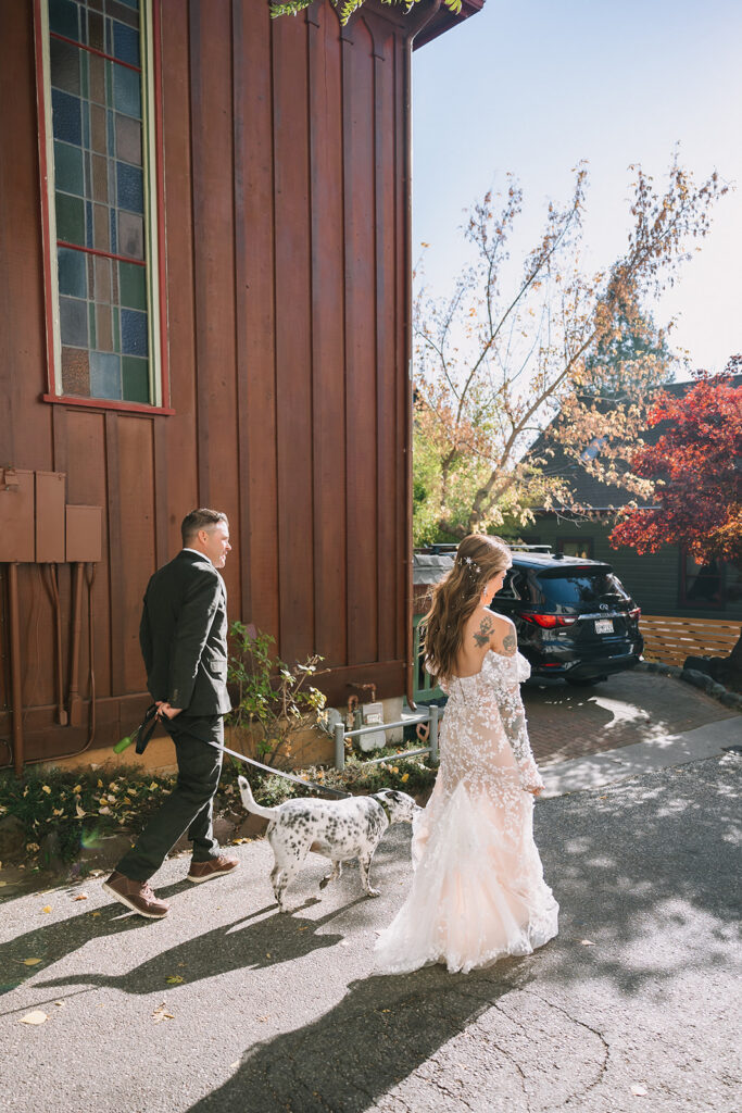 Bride and groom walking in Nevada City, California with their dog as they make their way to their wedding venue.