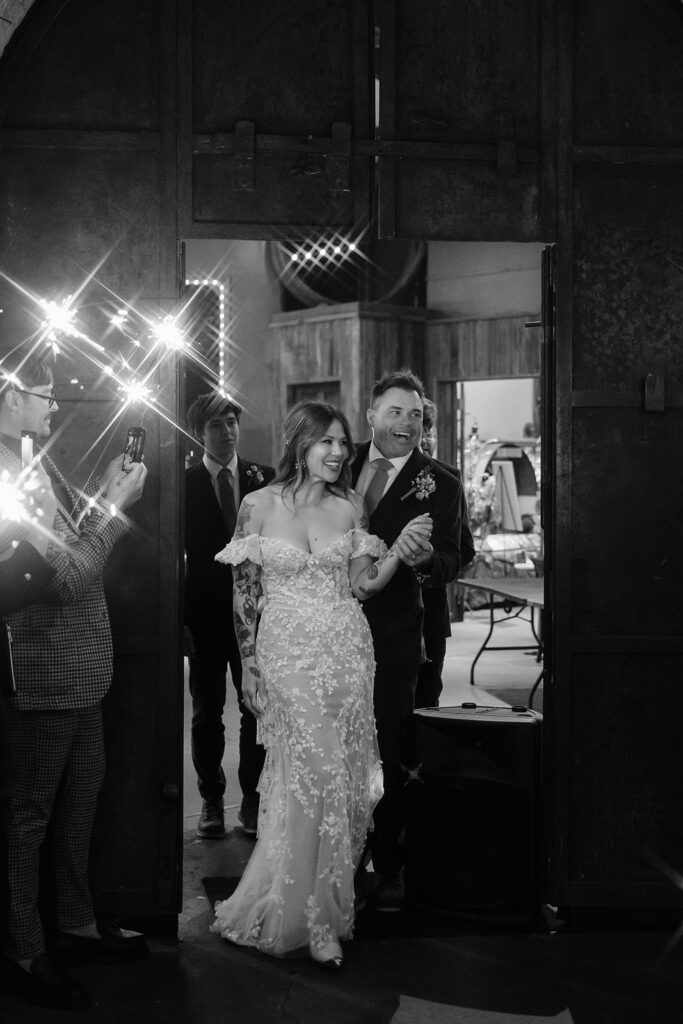 Bride and groom making a sparkler entrance into reception in Stone Hall at Miners Foundry wedding in Nevada City, California.