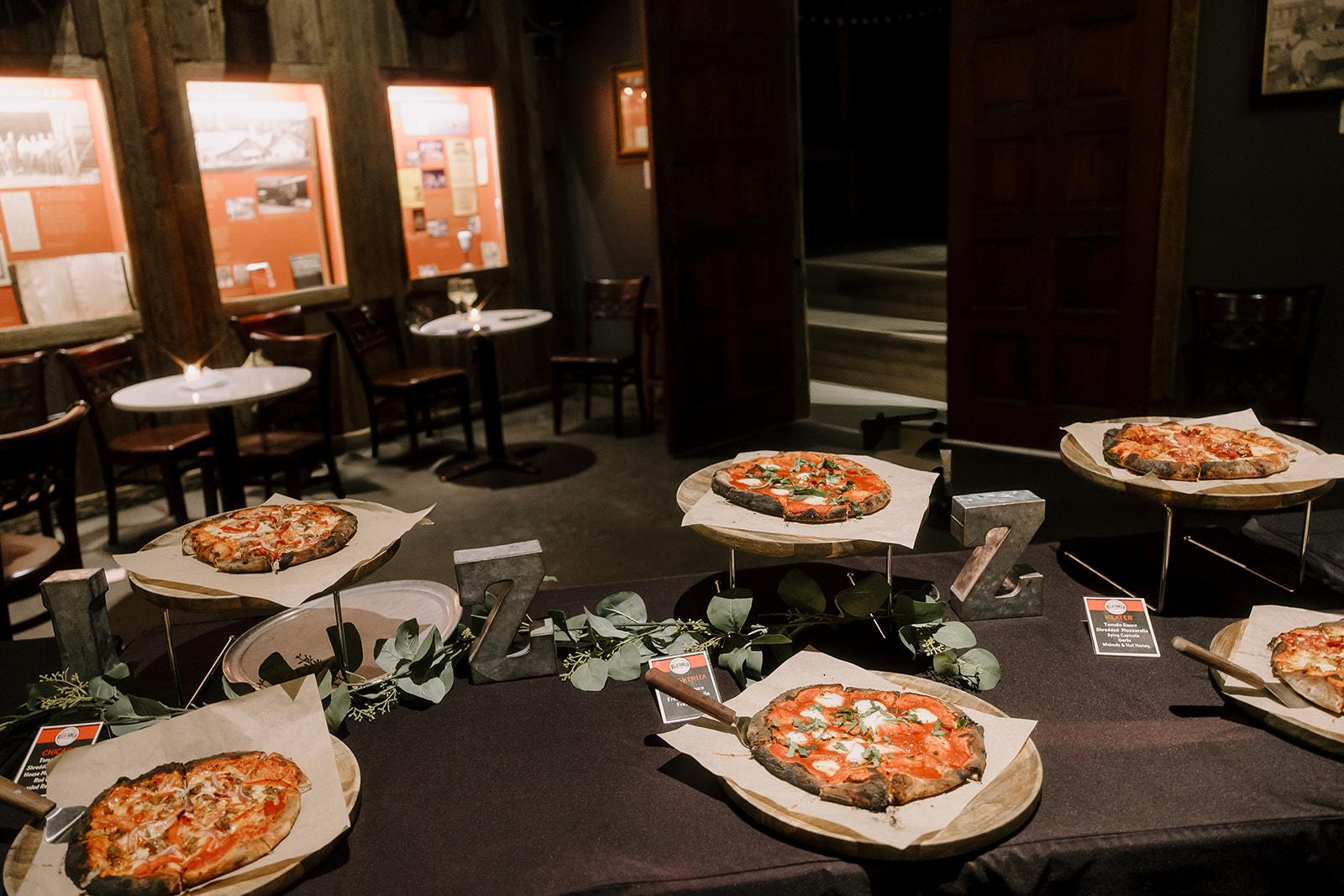 Pizza display with multiple pies arranged on tables during reception at Miners Foundry wedding in Nevada City, California.