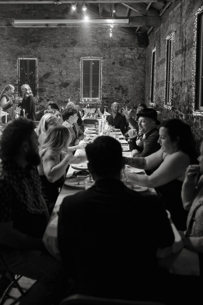 Guests seated at reception tables in Stone Hall at Miners Foundry wedding in Nevada City, California.
