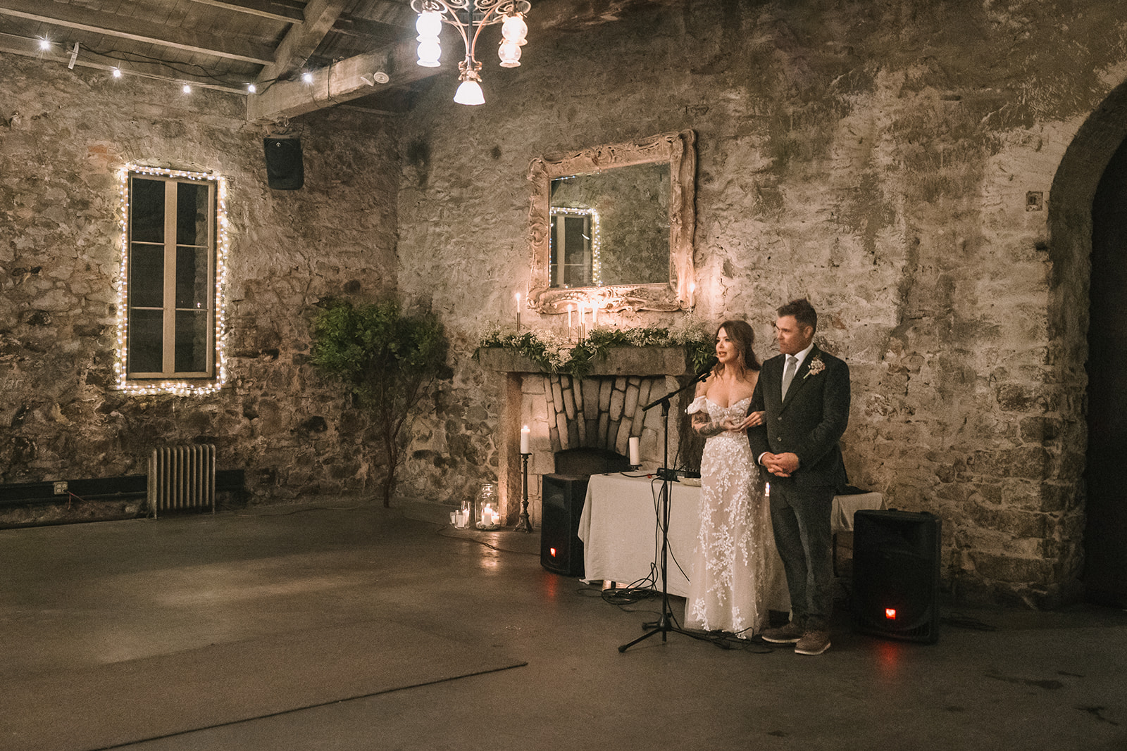 Bride and groom speaking to guests during reception in Stone Hall at Miners Foundry wedding in Nevada City, California.