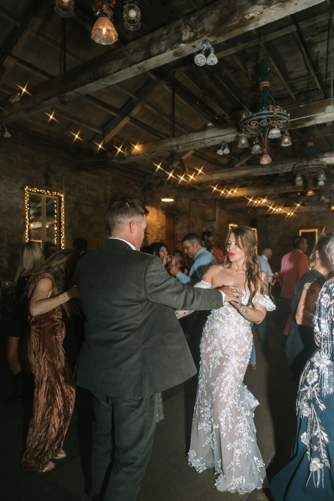 Bride and groom dancing together surrounded by guests at Miners Foundry wedding in Nevada City, California.