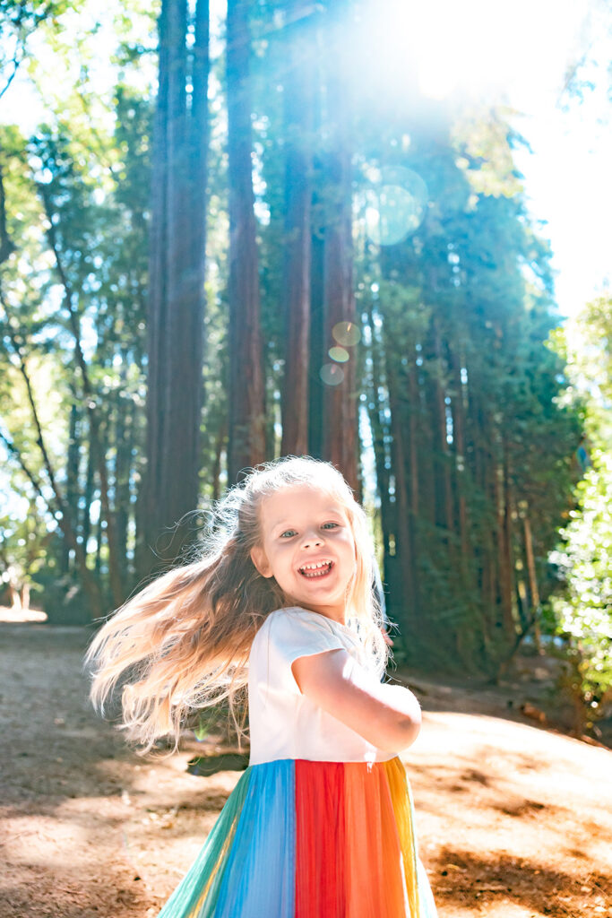 Little girl running up to the camera and smiling.