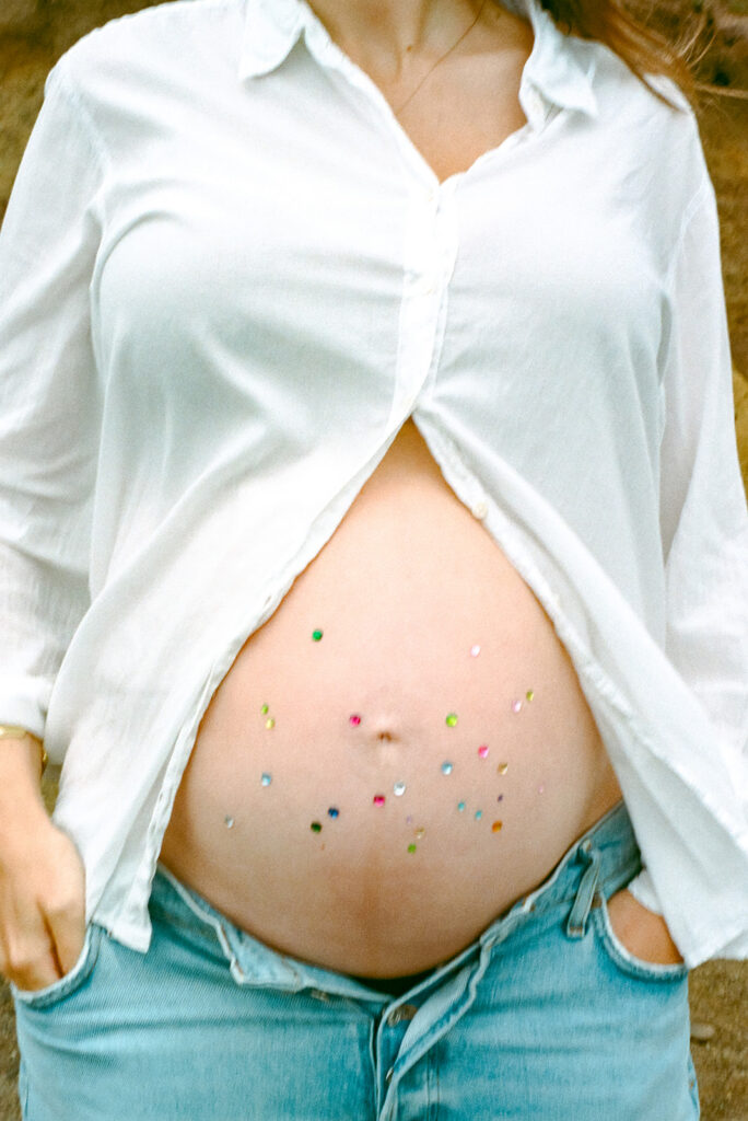 Pregnant mother with jeweled belly at Rodeo Beach in Marin Headlands photographed on film.