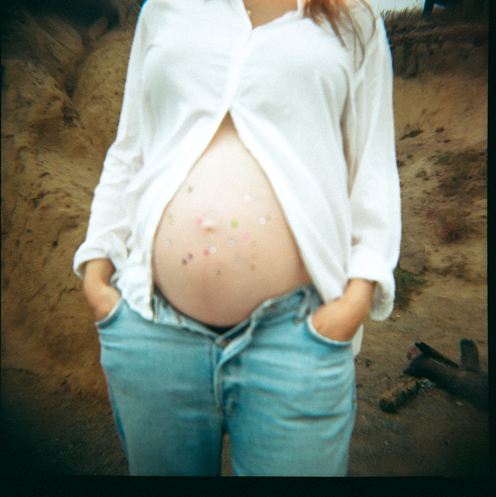 Jeweled pregnant belly portrait at Rodeo Beach maternity session captured on 35mm film.