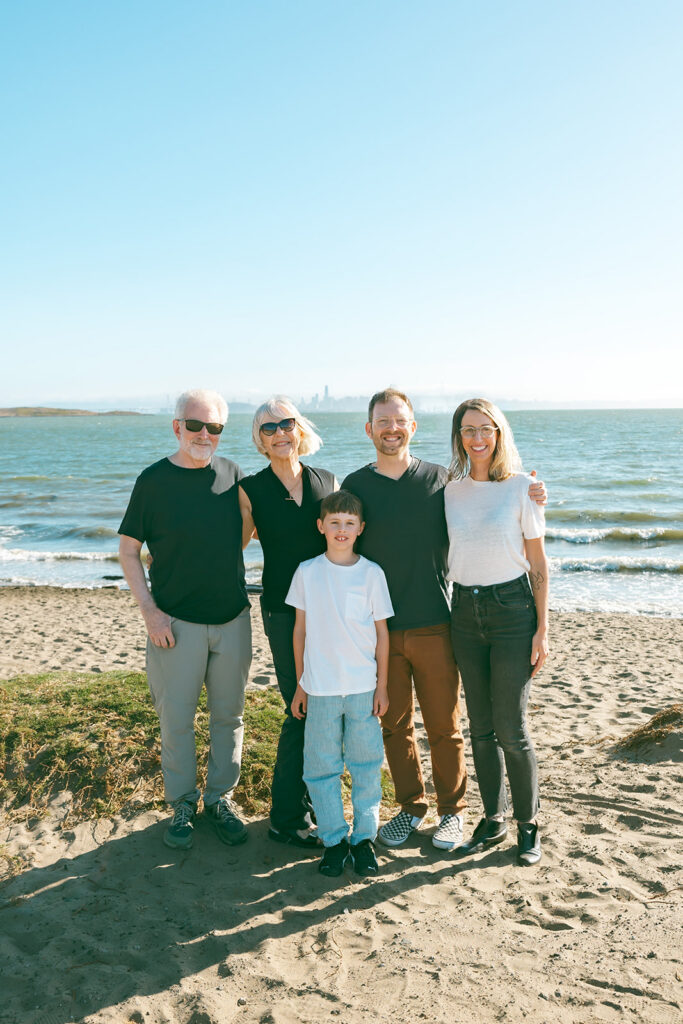Extended family portrait on the sand at Albany Bulb with the San Francisco Bay behind them.