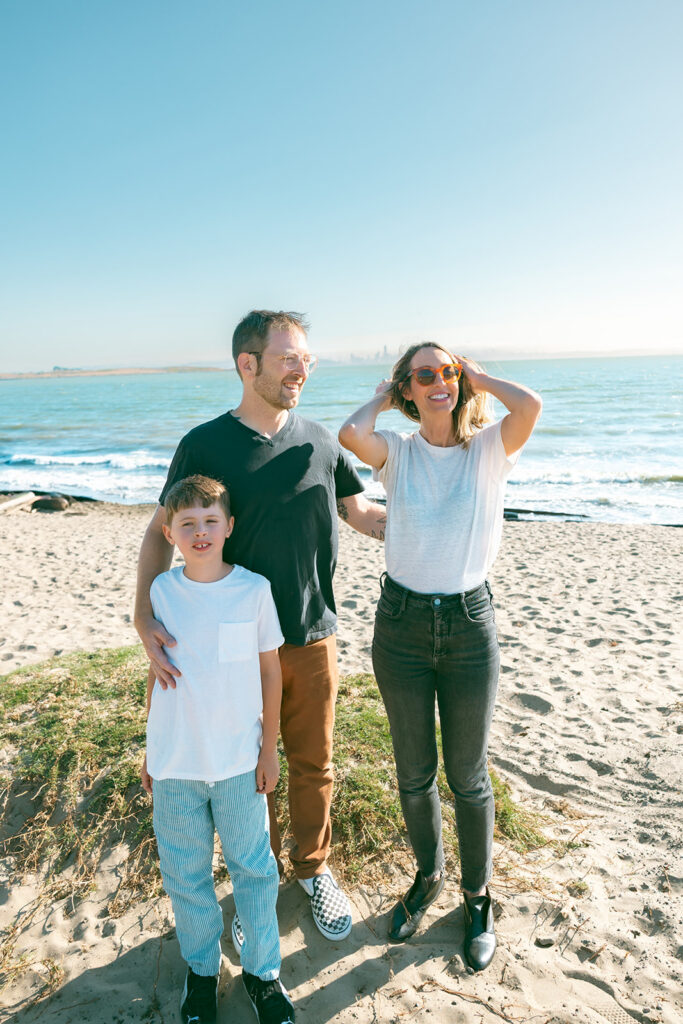 Family of three posing on the beach for their East Bay family photos in California. 