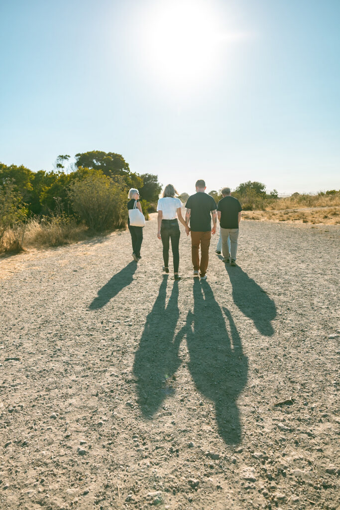 Three generations walking along a sunlit trail at Albany Bulb in Albany, California.