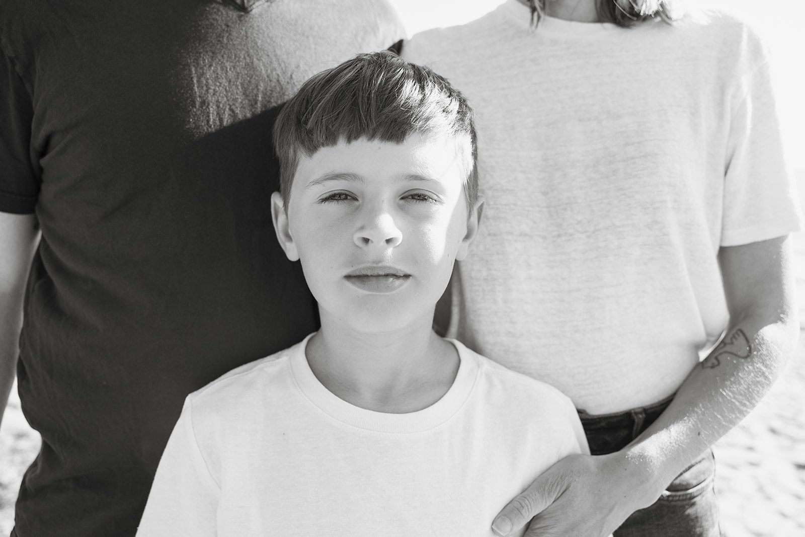 Close up shot of a young boy posing in front of his parents. 