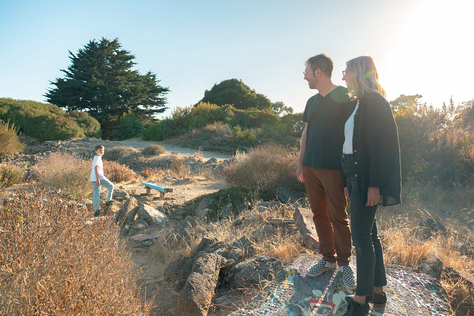 Family of three walking along the colorful rocks at Albany Bulb. 