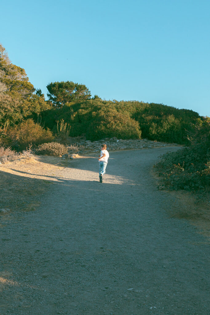 Young boy running down a dirt road in the East Bay.