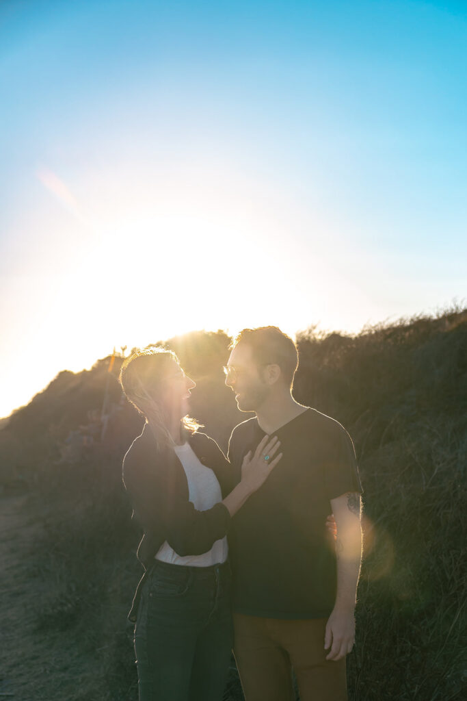 Man and woman posing along a trail at sunset in the East Bay.