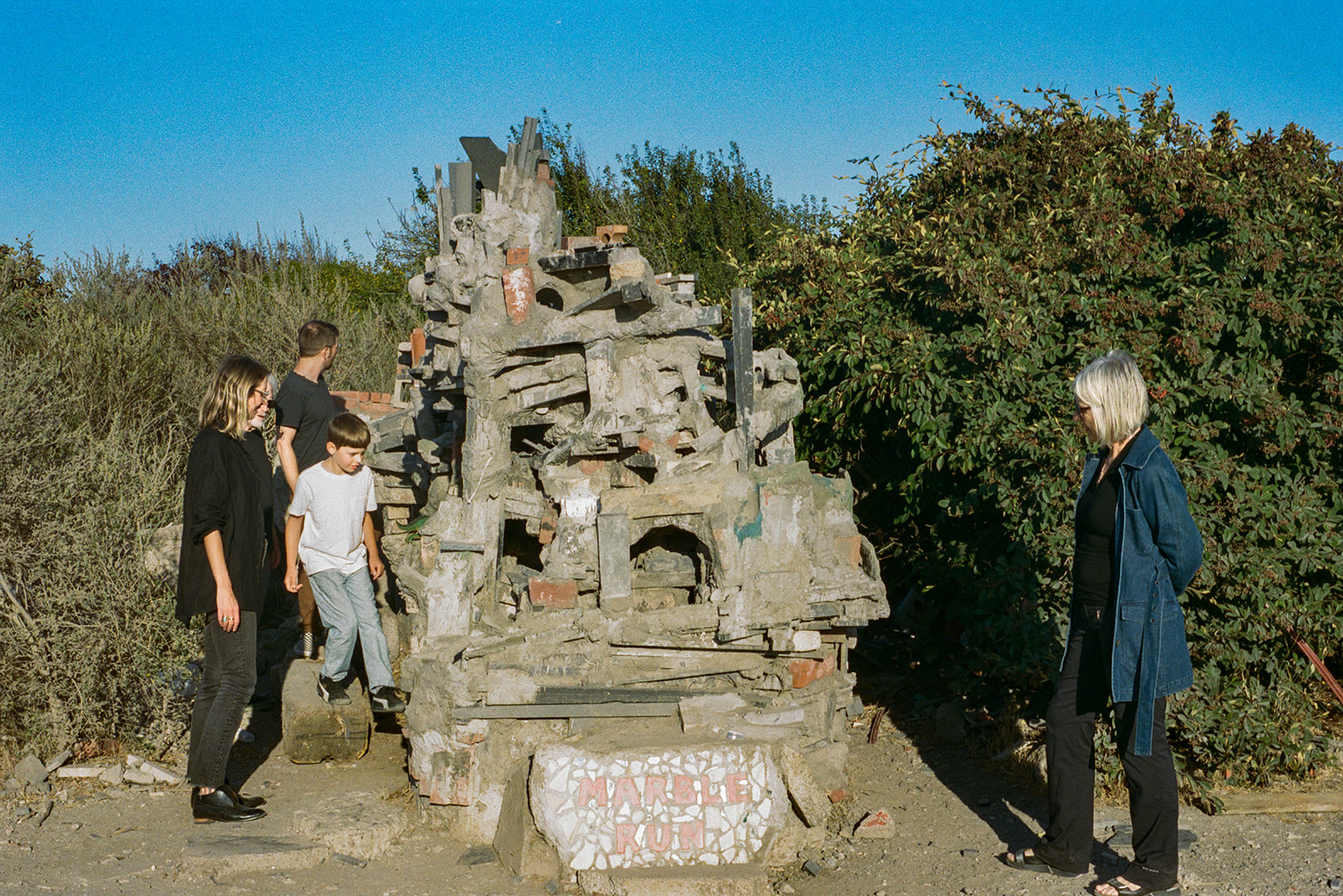 Family exploring Marble Run art installation during three generation family photos at Albany Bulb.