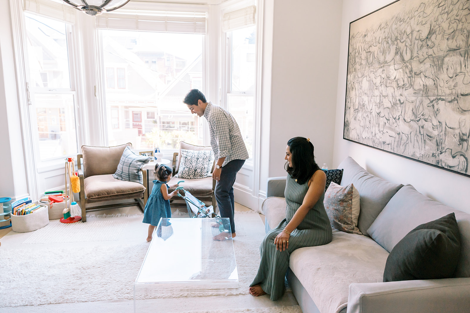 Family of three in the living room during their at-home family San Francisco maternity photos.