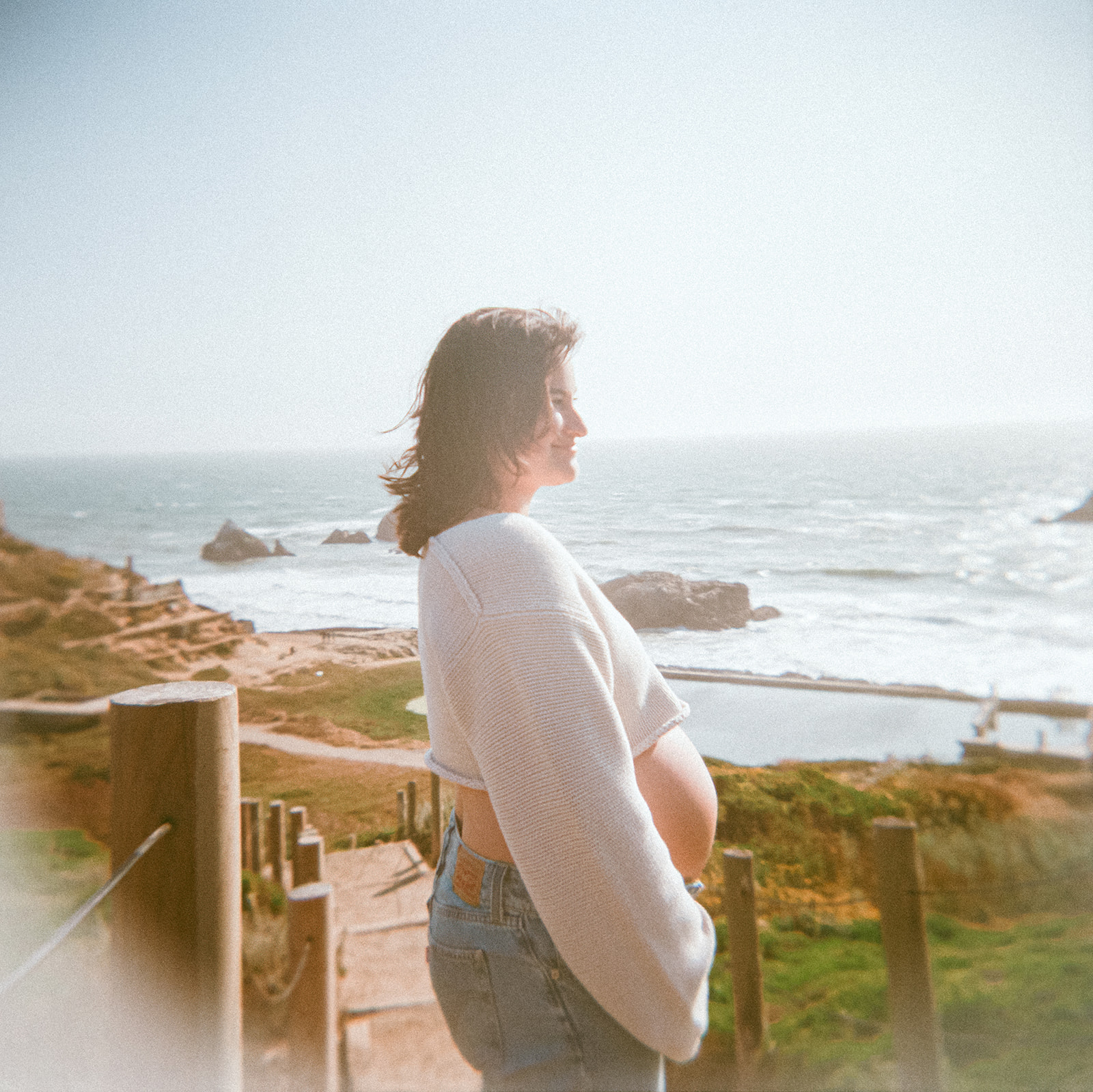 Woman admiring the views of Lands End and the ocean for her San Francisco maternity photos captured on film.