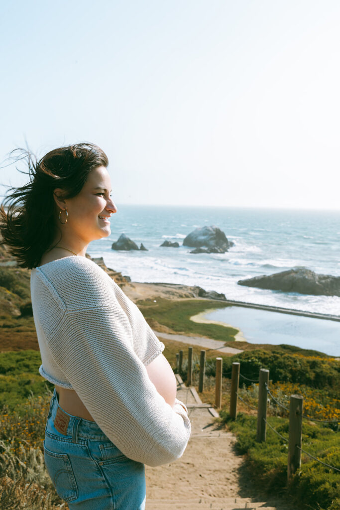 Pregnant woman admiring the views at Lands End and Sutro Baths during her San Francisco maternity photos. 