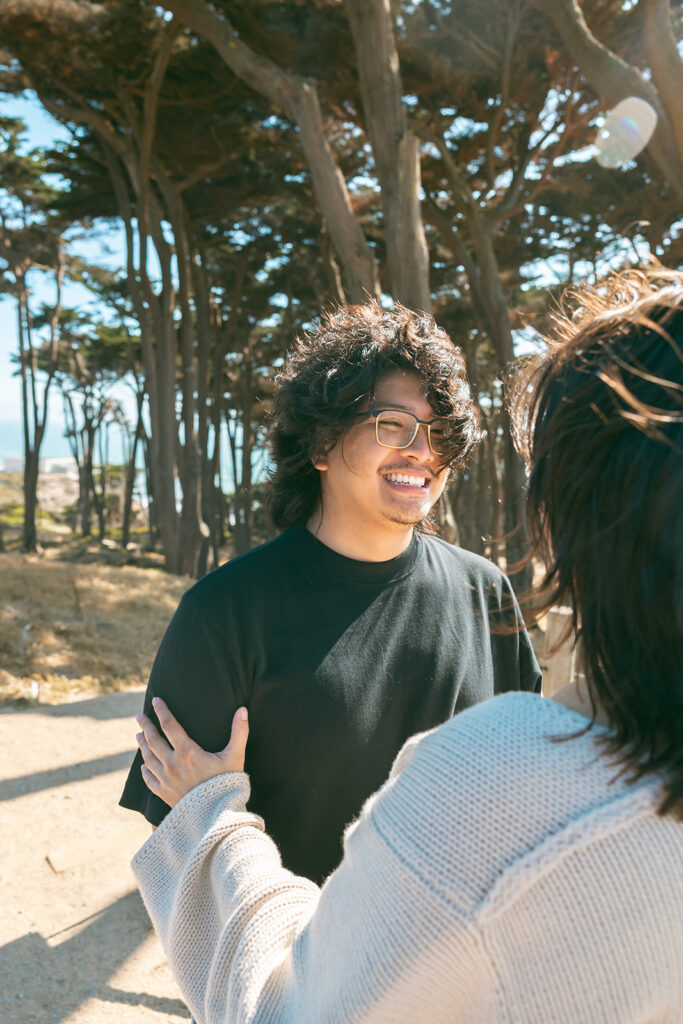 Man smiling at his pregnant partner during their photo sesion.