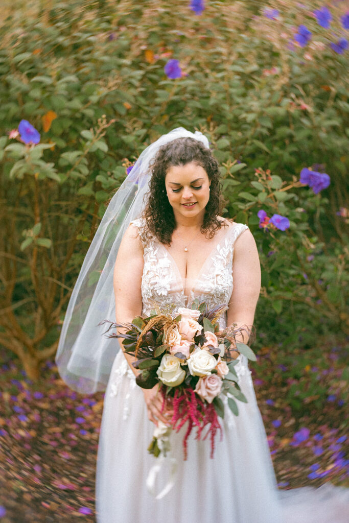 Bride posing in from of wildflowers during her San Francisco Botanical Garden wedding.