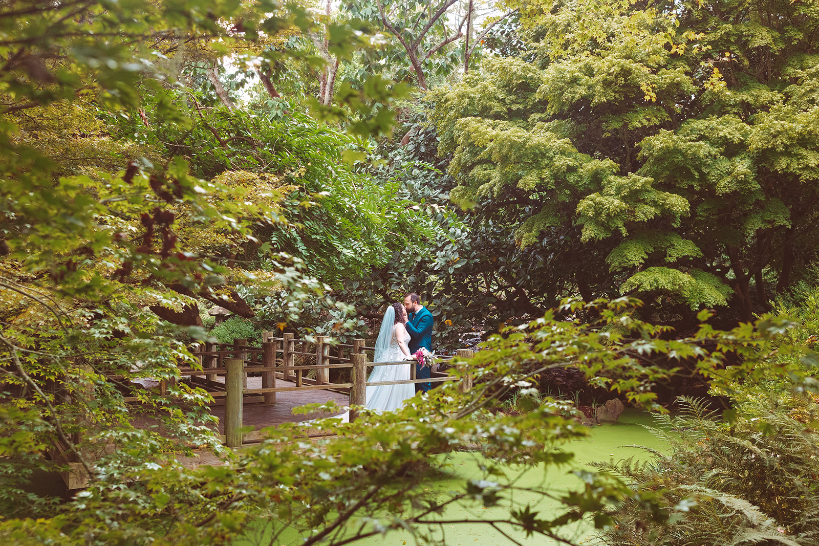 Bride and groom kissing on the Moon Viewing Garden platform at San Francisco Botanical Garden.