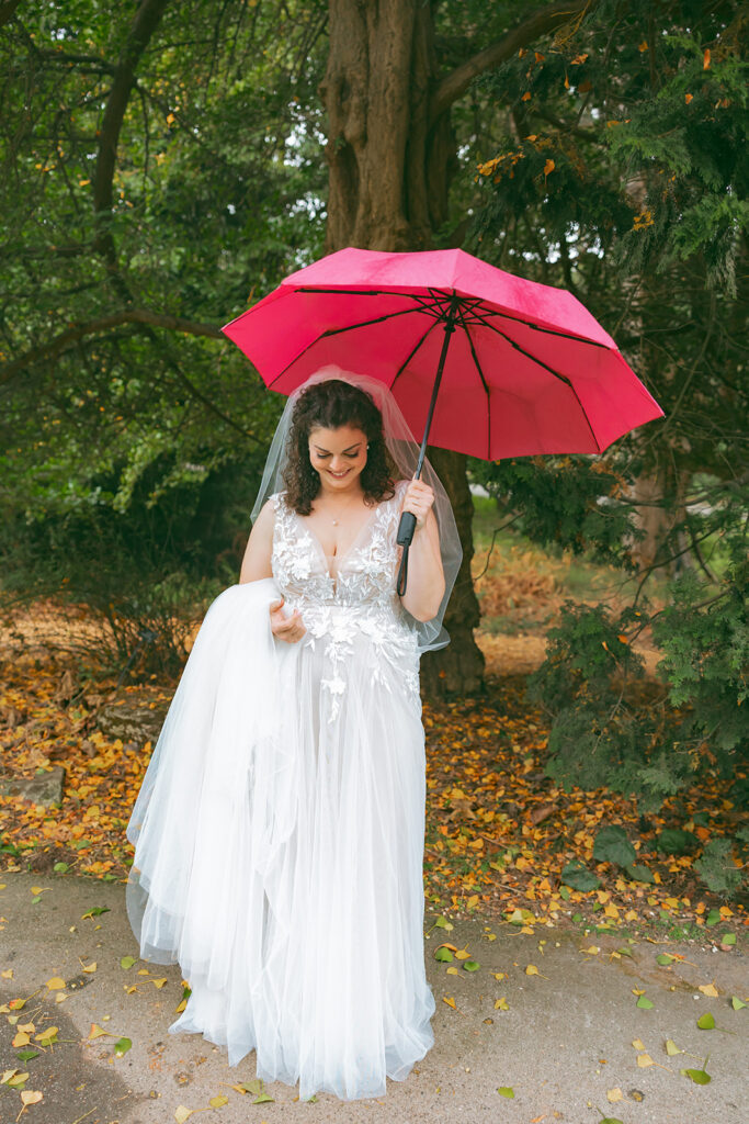 Bride posing under an umbrella during her San Francisco Botanical Garden wedding.