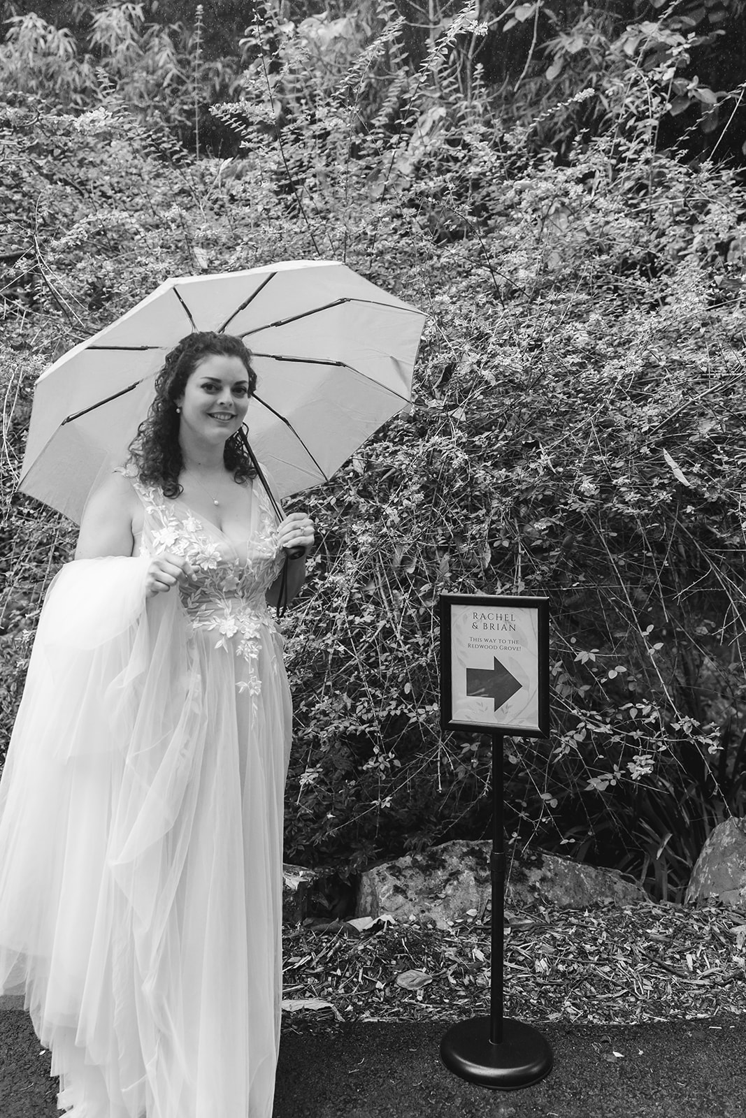Black and white photo of a bride of a bride walking to her San Francisco Botanical Garden wedding ceremony.