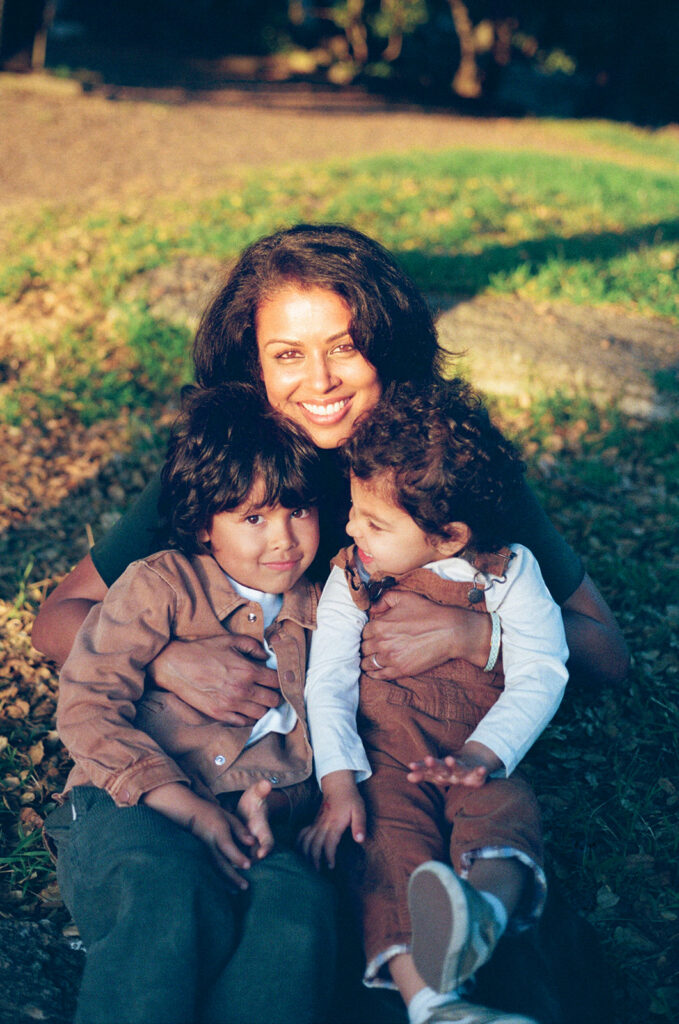35mm film photo of a mother cuddling her two sons during a family session at John Hinkel Park.