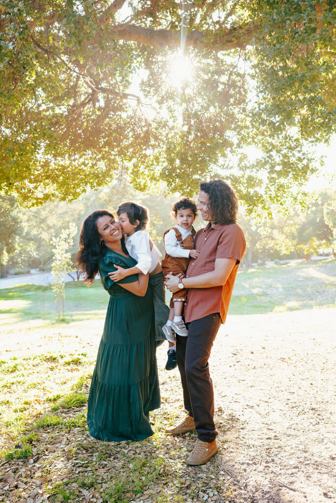 Family laughing together in golden fall light during an East Bay family photo session at John Hinkel Park.