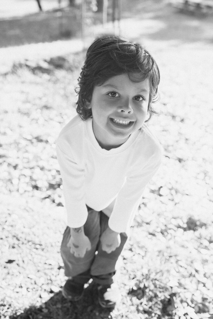 Black and white photo of a young boy smiling at the camera.