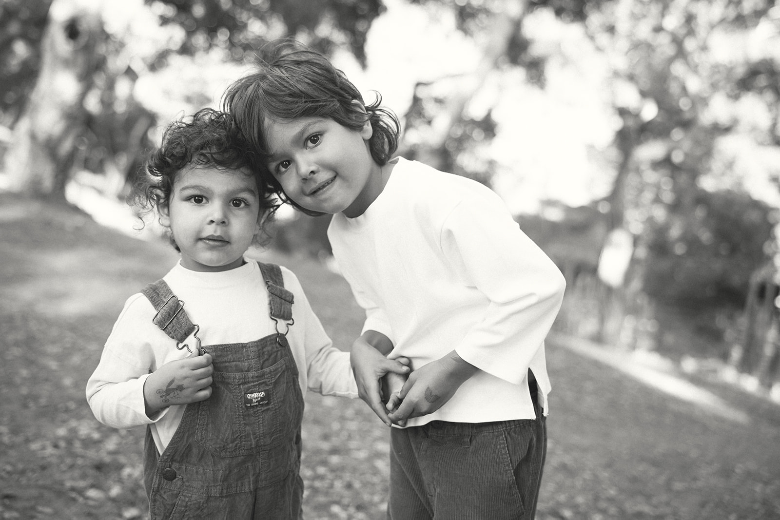 Black and white photo of two young brothers posing for a photo together.