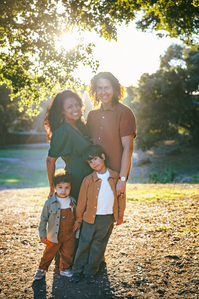 Family of for smiling during golden hour for their fall family photos at John Hinkel Park.