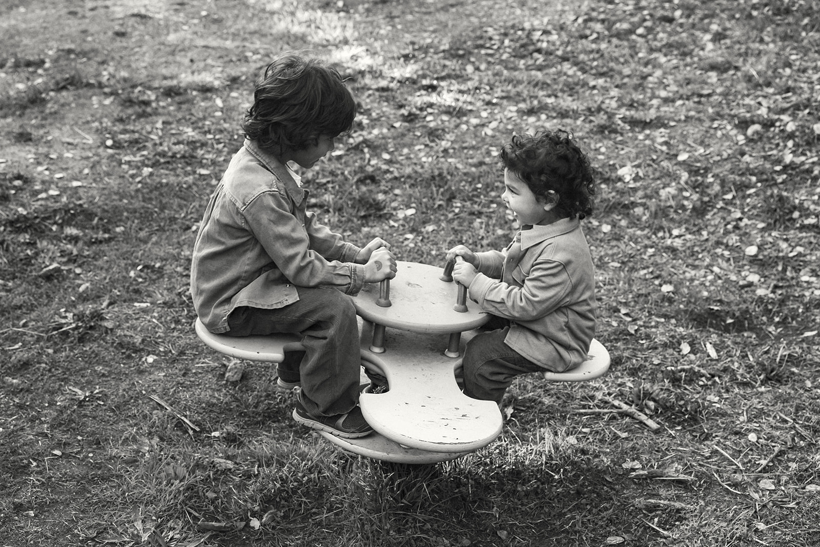 Two young boys playing together during a candid family photo session at John Hinkel Park.