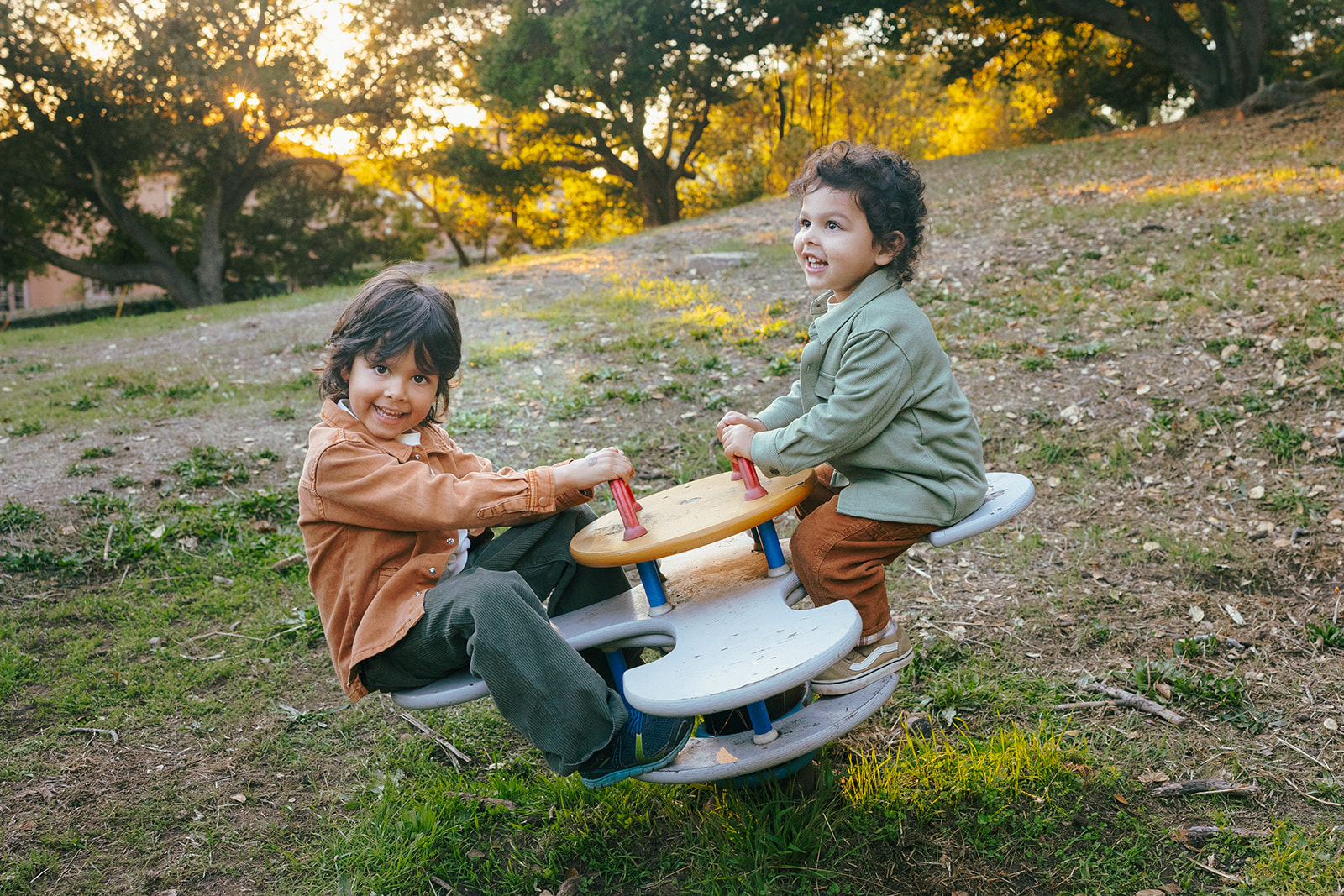 Two young boys playing together during a candid family photo session at John Hinkel Park.