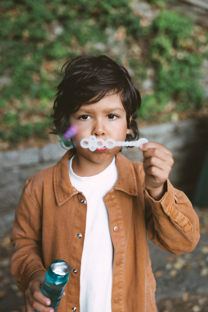 Young boy blowing bubbles during his fall family photos in the East Bay.
