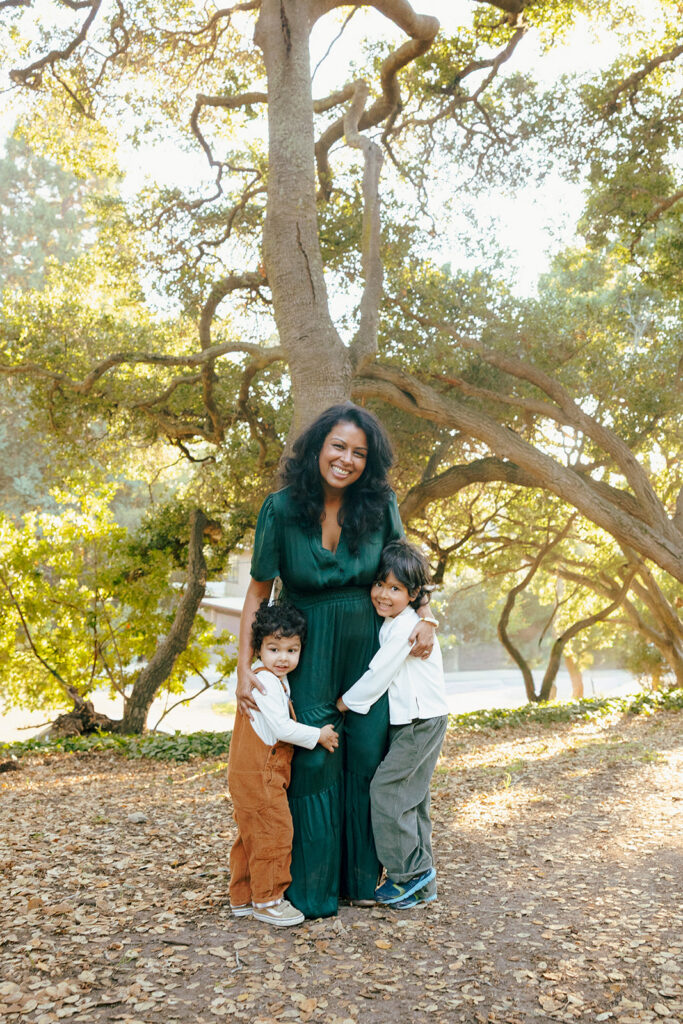 Mother smiling and posing with her two young sons during their fall family photoshoot in the East Bay.