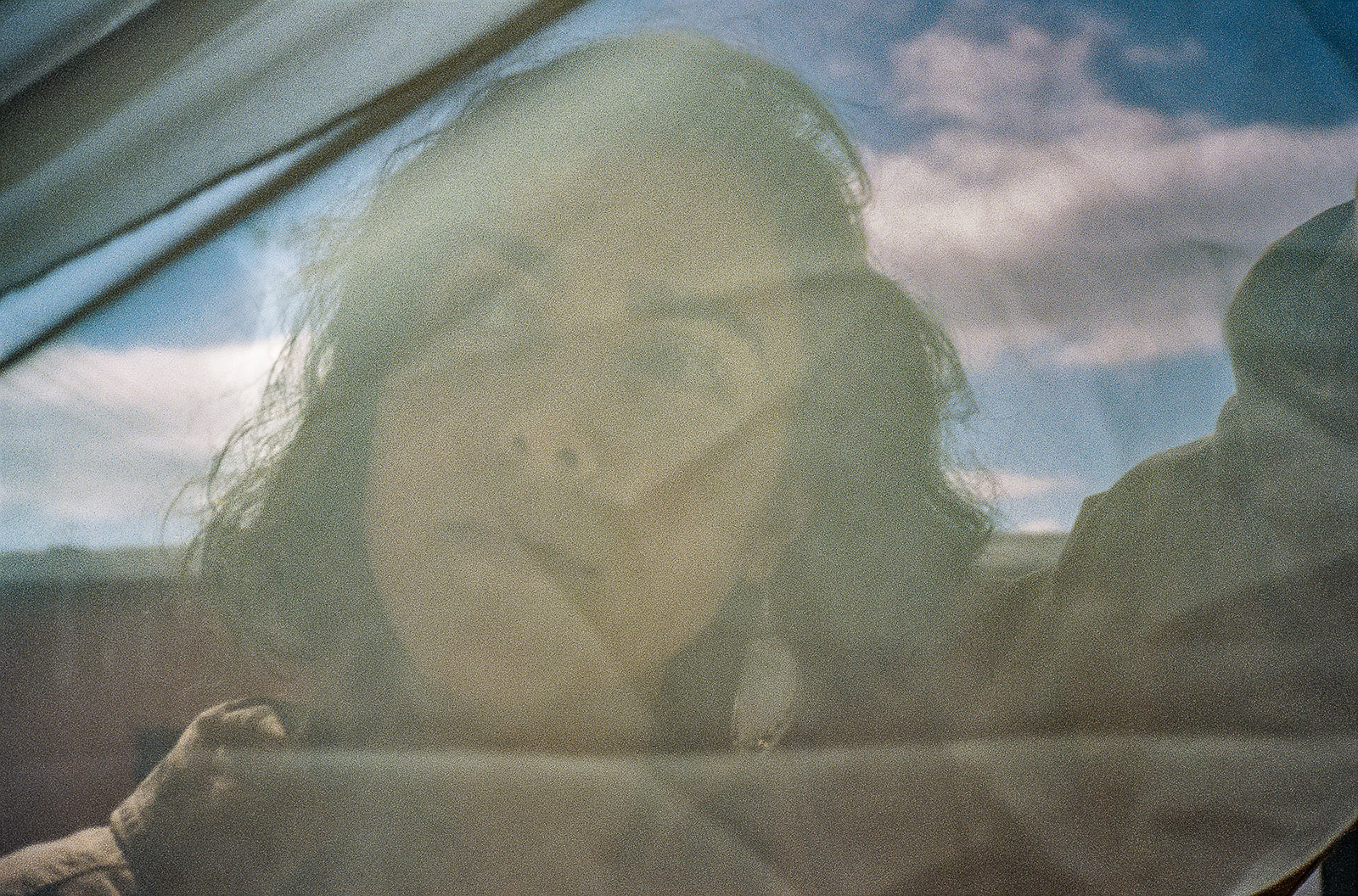 Creative film portrait of therapist holding up a sheet over her face.