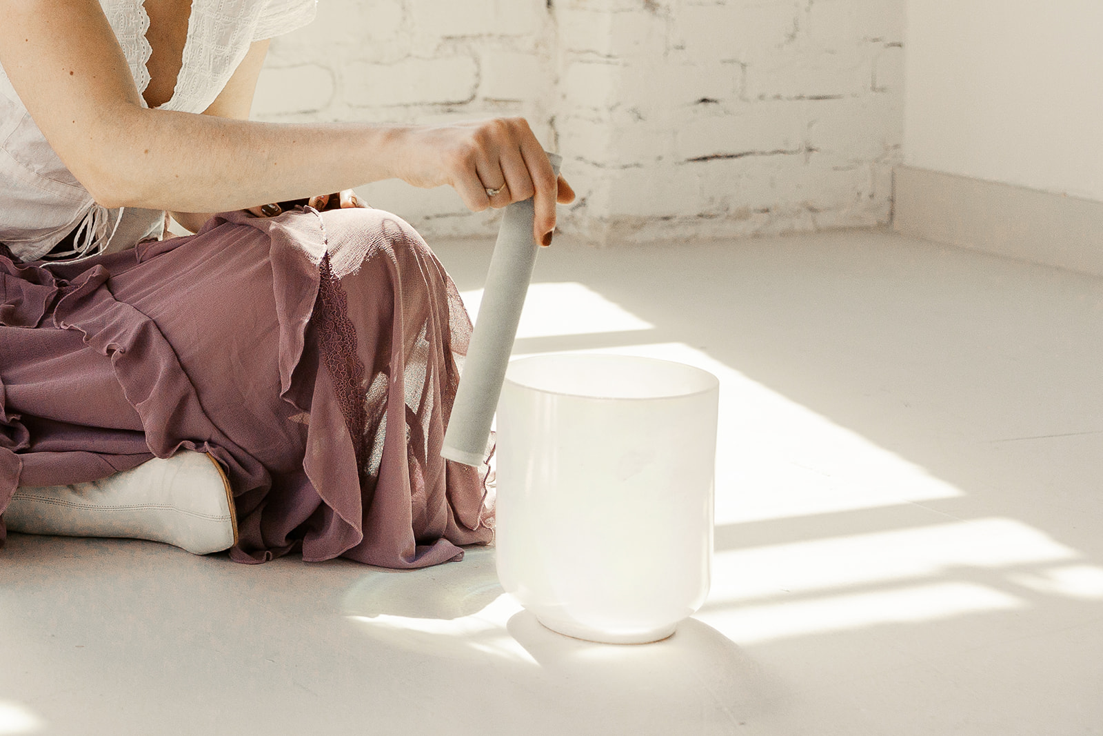 Clo9se up shot of a therapist using sound bowls during her brand photoshoot in a studio in the Bay Area.