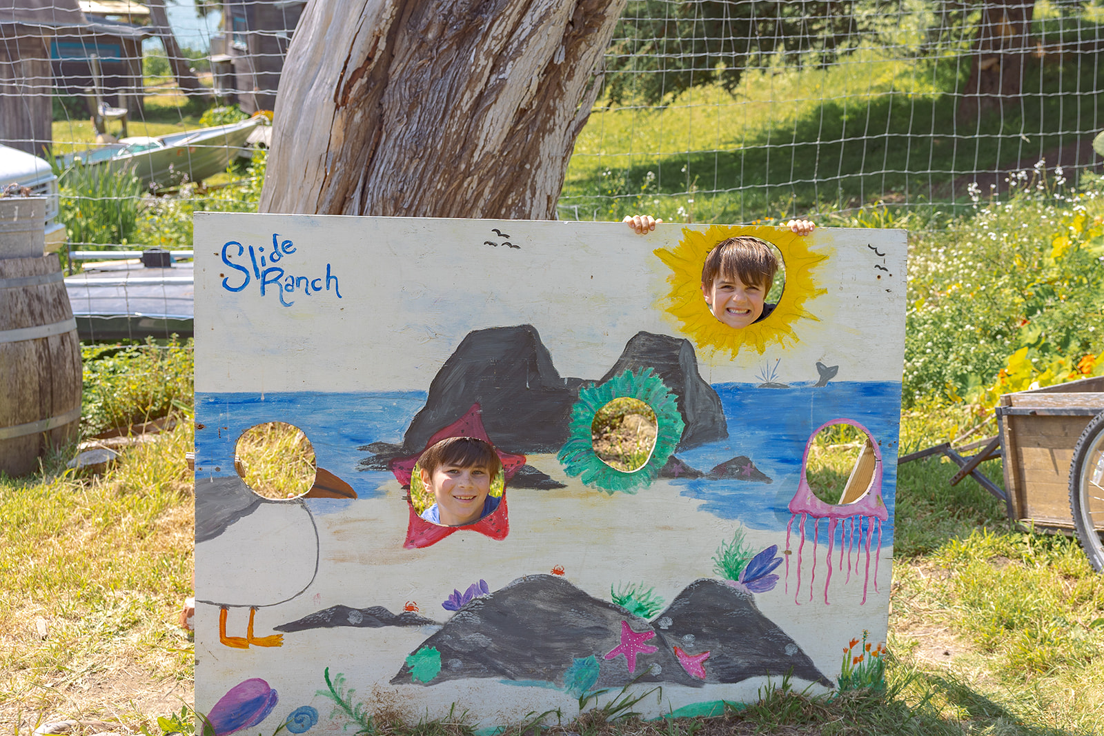 Boys posing with a Slide Ranch painting. 