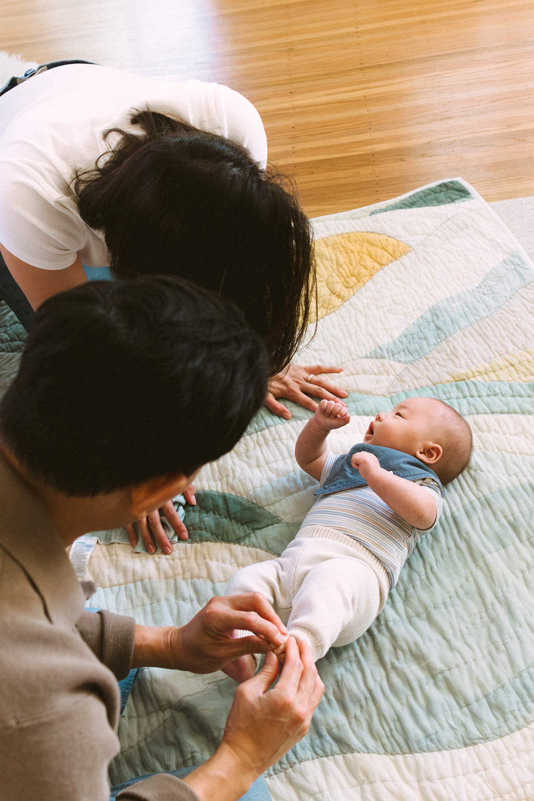 Parents playing with their newborn baby during an at-home Bay Area newborn photography session.