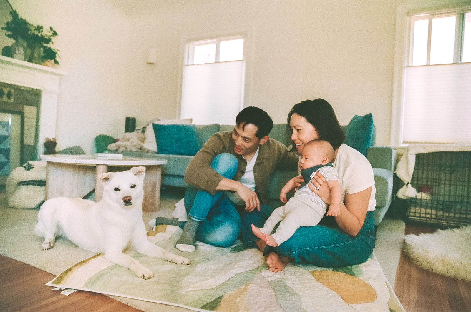 Film photo of a couple with their baby and dog sitting on their living room floor for a Bay Area newborn photography session.