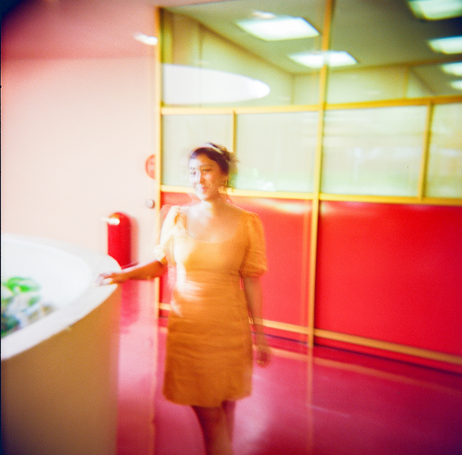Colorful 35mm film engagement photo of a woman in a yellow dress inside Marin County Civic Center.