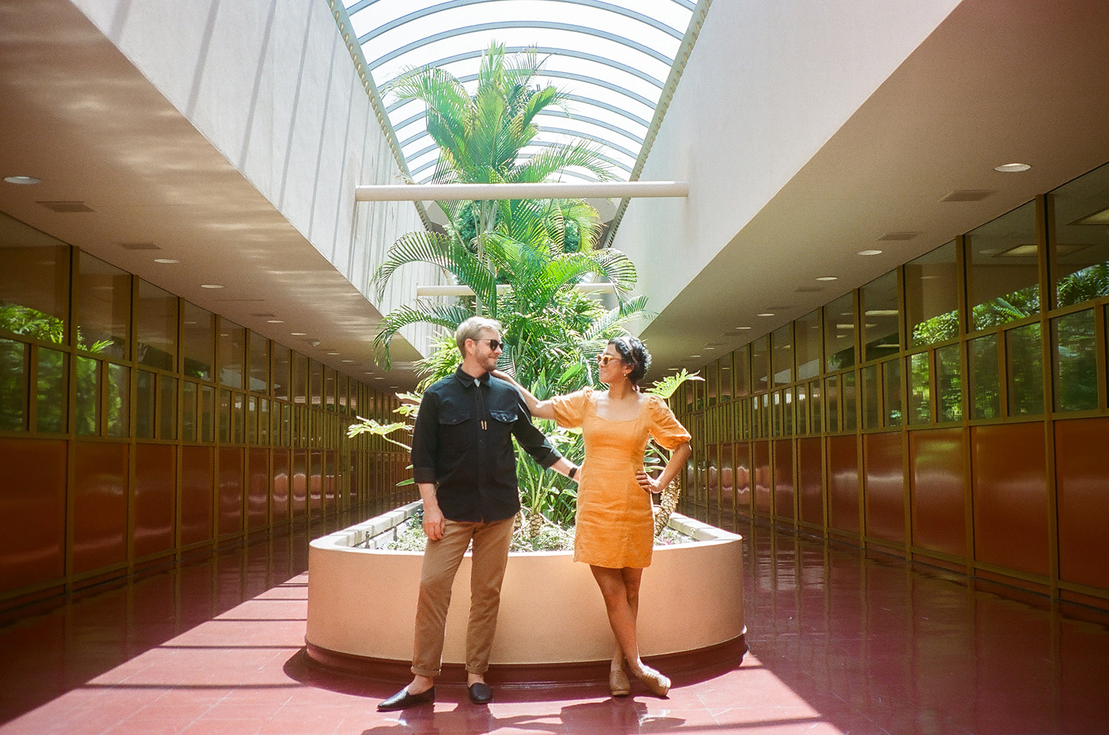 Couple posing together inside Marin County Civic Center for colorful film-inspired Bay Area engagement photos on 35mm film.