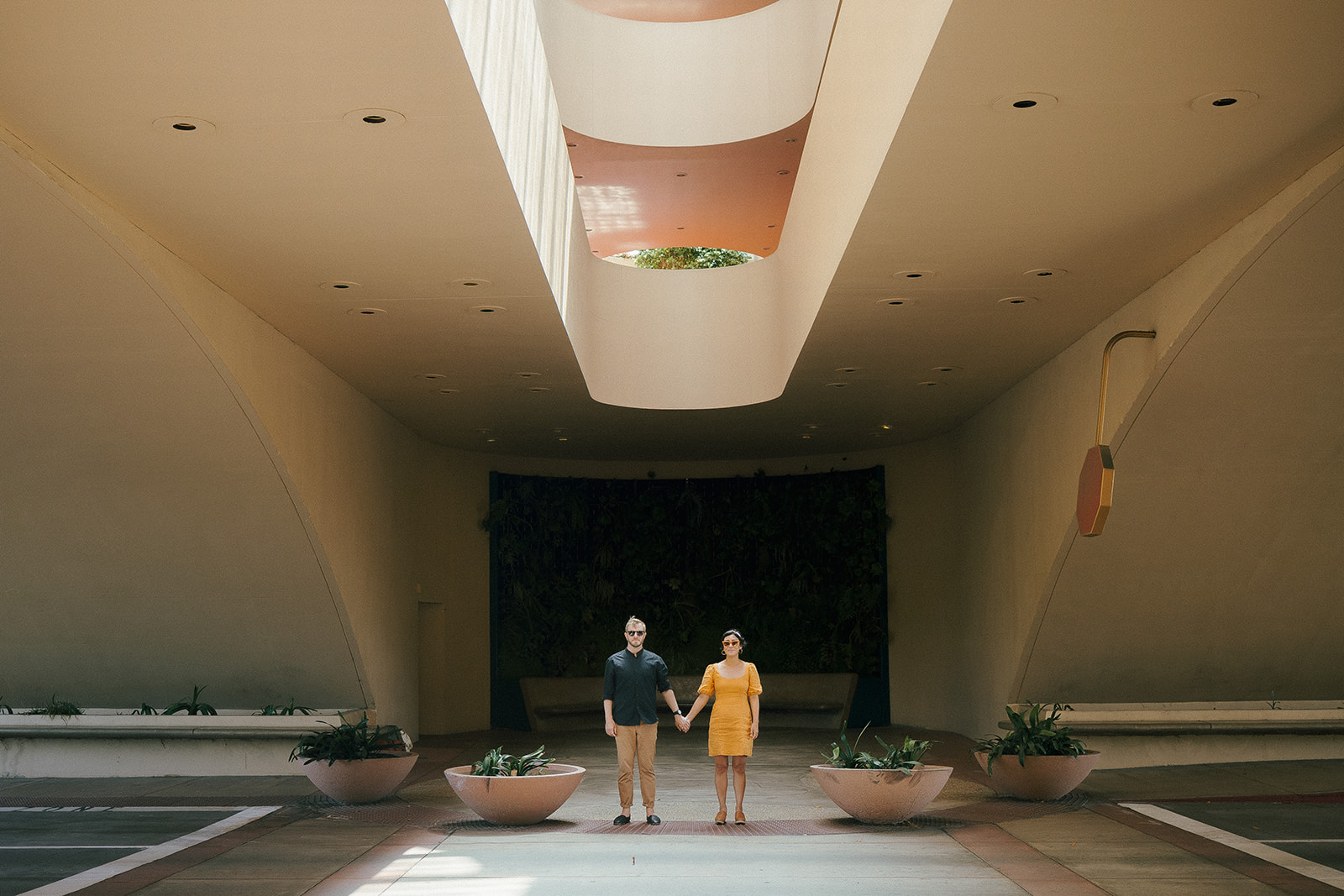 Couple holding hands during their Wes Anderson style engagement photos at Marin County Civic Center.