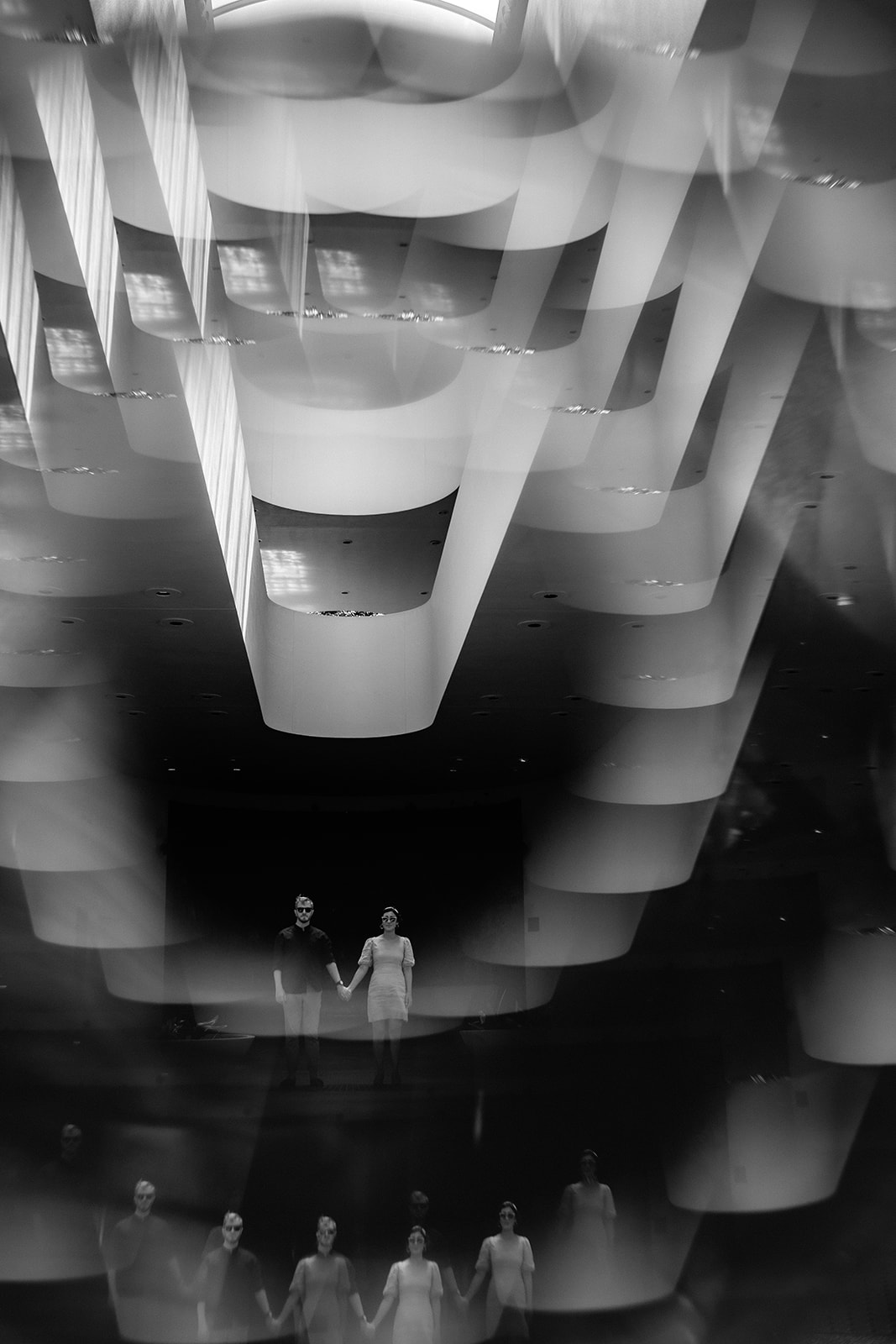 Black and white engagement photo with reflections and dramatic architecture at Marin County Civic Center.
