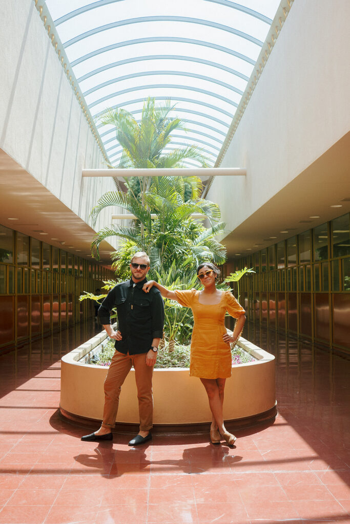 Couple posing in colorful light inside Marin County Civic Center for creative Bay Area engagement photos.